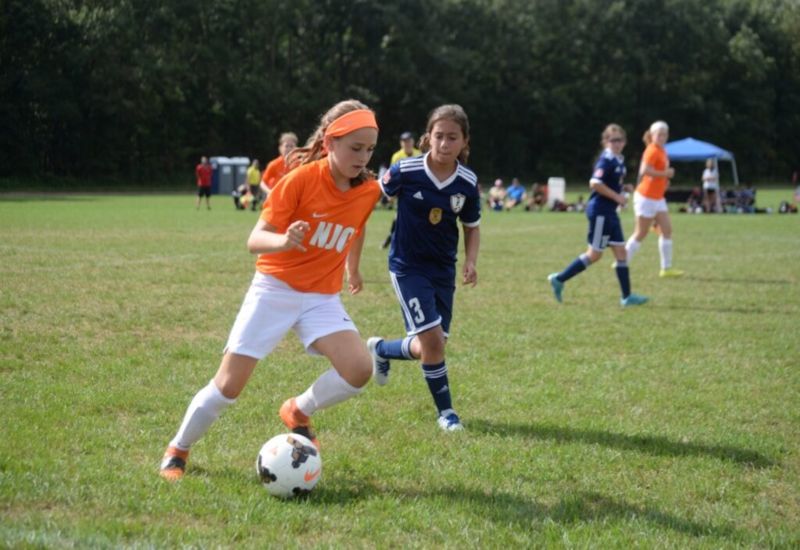The soccer ball passing from girl at ground